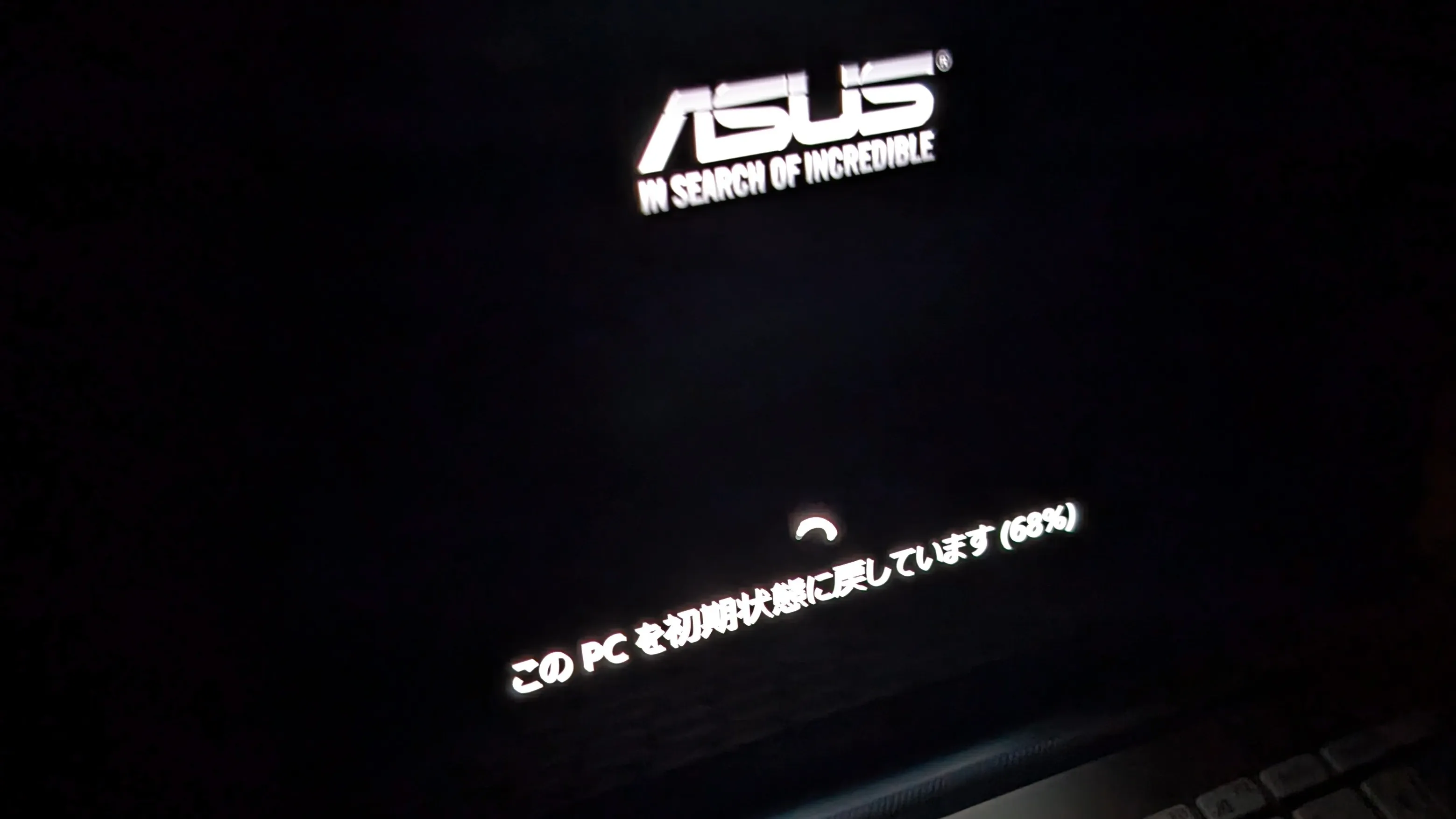 Windowsのリセット中の画面。中央にはASUSのロゴが表示され、その下にはプログレスバーとともに［このPCを初期状態に戻しています（65%）］というメッセージが表示されている