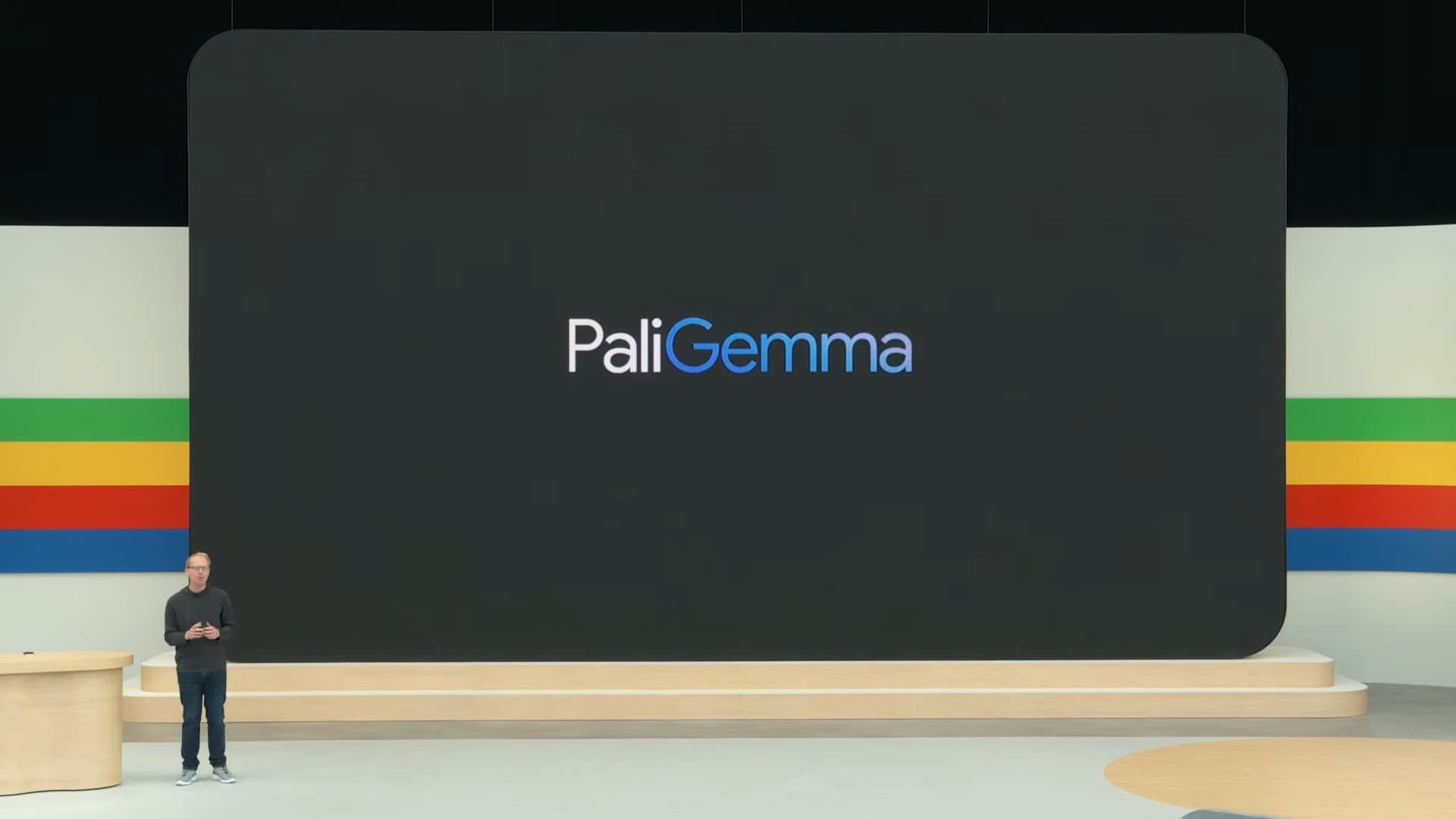 ステージの背後に「PaliGemma」と書かれたスライドが表示されている写真