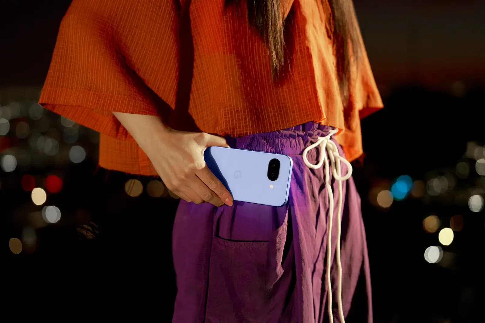 女性がPixel 9aをポケットに入れようとしているようすの写真